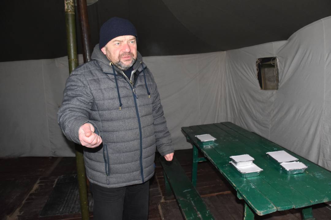 Микола Романов показує намет і те, чим зможуть напоїти й нагодувати замерзлого
